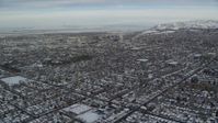 5.5K stock footage aerial video fly over snowy homes toward Downtown Salt Lake City at sunrise in Utah Aerial Stock Footage | AX124_191