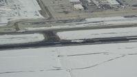5.5K stock footage aerial video track an airliner touching down on runway at Salt Lake City International Airport with winter snow, Utah Aerial Stock Footage | AX125_012