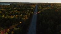 5.5K stock footage aerial video tracking car on road through forest, autumn, Stockton Springs, Maine, sunset Aerial Stock Footage | AX149_129