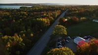 5.5K stock footage aerial video tracking car on road through forest in autumn, Stockton Springs, Maine, sunset Aerial Stock Footage | AX149_130