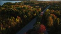 5.5K stock footage aerial video tracking car on road through forest, autumn, Stockton Springs, Maine, sunset Aerial Stock Footage | AX149_131