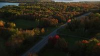 5.5K stock footage aerial video tracking car on road through forest, autumn, Stockton Springs, Maine, sunset Aerial Stock Footage | AX149_132
