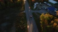 5.5K stock footage aerial video tracking car on road through forest in autumn, Stockton Springs, Maine, sunset Aerial Stock Footage | AX149_134