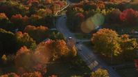 5.5K stock footage aerial video tracking car on road through quaint town, autumn, Stockton Springs, Maine, sunset Aerial Stock Footage | AX149_141