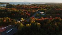 5.5K stock footage aerial video tracking a car on road passing by small town, autumn, Stockton Springs, Maine, sunset Aerial Stock Footage | AX149_144