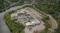 5.5K stock footage aerial video flying over water treatment plant along a river, autumn, Lowell, Massachusetts Aerial Stock Footage | AX152_126