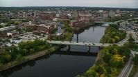 5.5K stock footage aerial video flying over bridge on a river toward abandoned factory, autumn, Lowell, Massachusetts Aerial Stock Footage | AX152_128