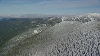 5.5K stock footage aerial video panning across evergreen and snowy forest to mountain ridges, Cascade Range, Oregon Aerial Stock Footage | AX154_107