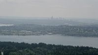 5K stock footage aerial video of skyline in fog seen from tree-lined lake shores, Seattle, Washington Aerial Stock Footage | AX46_019