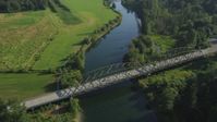 5K stock footage aerial video approach a bridge spanning the Snoqualmie River and tilt to a bird's eye view in Carnation, Washington Aerial Stock Footage | AX48_033