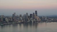 5K stock footage aerial video of a view of the Seattle Waterfront and the Downtown Seattle skyline from Elliott Bay in Washington, sunset Aerial Stock Footage | AX50_043