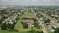 5K stock footage aerial video fly over abandoned school to approach homes in the Lower Ninth Ward, New Orleans, Louisiana Aerial Stock Footage | AX59_056