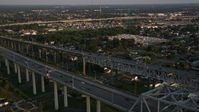 5K stock footage aerial video fly over the convention center to track cars on Crescent City Connection Bridge at sunset, New Orleans, Louisiana Aerial Stock Footage | AX61_020