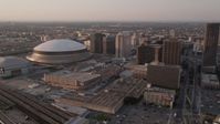 5K stock footage aerial video flyby Plaza Tower to approach Superdome and New Orleans Arena at sunset, New Orleans, Louisiana Aerial Stock Footage | AX61_027