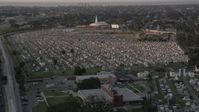 5K stock footage aerial video fly over Greenwood Cemetery tombs and approach the church at sunset, New Orleans, Louisiana Aerial Stock Footage | AX61_031