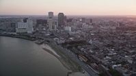 5K stock footage aerial video of skyscrapers in Downtown New Orleans seen from the Mississippi River at sunset, Louisiana Aerial Stock Footage | AX61_063
