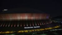 5K stock footage aerial video of ascending from the Mercedes-Benz Superdome at night, New Orleans, Louisiana Aerial Stock Footage | AX62_001