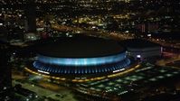 5K stock footage aerial video orbit the Superdome as it changes colors at night, New Orleans, Louisiana Aerial Stock Footage | AX63_020