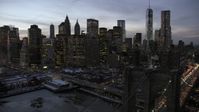 4.8K stock footage aerial video fly over Brooklyn Bridge toward Lower Manhattan skyline in winter, New York City, twilight Aerial Stock Footage | AX66_0367