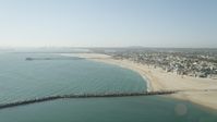 4.8K stock footage aerial video fly over breakwater to approach the pier by beach and homes, Seal Beach, California Aerial Stock Footage | AX68_122