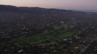 4.8K stock footage aerial video tilt to golf course ringed by mansions at twilight in Pacific Palisades, California Aerial Stock Footage | AX69_049