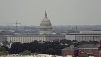 4.8K stock footage aerial video of the United States Capitol seen while passing smoke stacks in Washington DC Aerial Stock Footage | AX74_038E
