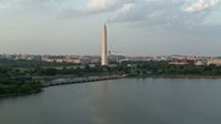 4.8K stock footage aerial video of Washington Monument seen from Tidal Basin, Washington D.C., sunset Aerial Stock Footage | AX76_060