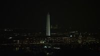 4.8K stock footage aerial video of the Washington Monument behind office buildings in Washington, D.C., night Aerial Stock Footage | AX77_035E