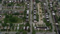 4.8K stock footage aerial video tilting from urban row houses, tilt up revealing Herring Run Park, public housing in Baltimore, Maryland Aerial Stock Footage | AX78_122