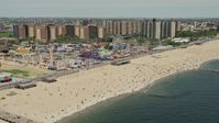4.8K stock footage aerial video flying over beach goers on Coney Island Beach to approach Luna Park, Brooklyn, New York City Aerial Stock Footage | AX83_212E