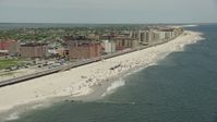 4.8K stock footage aerial video tilting to a Crowd of Sunbathers on the Beach, Long Beach, New York Aerial Stock Footage | AX83_241