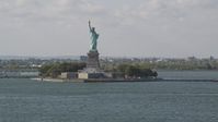 4K stock footage aerial video tilt from New York Harbor, revealing Statue of Liberty, New York, New York Aerial Stock Footage | AX88_102