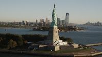 4K stock footage aerial video Orbiting Statue of Liberty, revealing Lower Manhattan skyline, New York, sunrise Aerial Stock Footage | AX90_150