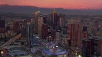 HD stock footage aerial video flying away from towering Downtown Los Angeles skyscrapers, reveal arena at sunset, California Aerial Stock Footage | CAP_018_098