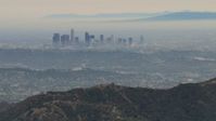 HD stock footage aerial video of flying over Verdugo Mountains, by hazy Downtown Los Angeles, California Aerial Stock Footage | CBAX01_117