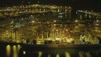 4K stock footage aerial video of flying by cargo ship, cranes, containers, Port of Long Beach, California, night Aerial Stock Footage | DCA07_134