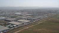4K stock footage aerial video pan across the border fence to reveal warehouse buildings and urban neighborhoods, US/Mexico Border, Tijuana Aerial Stock Footage | DCA08_073N