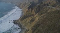 5K stock footage aerial video Pan to reveal waves rolling toward cliffs, Big Sur, California Aerial Stock Footage | DCSF03_045