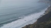 5K stock footage aerial video Tilt to bird's eye of ocean waves rolling toward cliffs, Big Sur, California Aerial Stock Footage | DCSF03_046