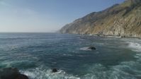 5K stock footage aerial video Fly low over Pacific Ocean to approach coastal cliffs, Big Sur, California Aerial Stock Footage | DCSF03_052