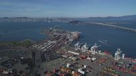 5K stock footage aerial video Tilt from shipping containers at the Port of Oakland, reveal Bay Bridge, San Francisco Bay, California Aerial Stock Footage | DCSF05_004