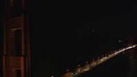 5K stock footage aerial video Tilt up from traffic and fly by Golden Gate Bridge, San Francisco, California, night Aerial Stock Footage | DCSF06_041