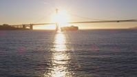 5K stock footage aerial video Low approach to a cargo ship near Golden Gate Bridge, San Francisco, California, sunset Aerial Stock Footage | DCSF07_036