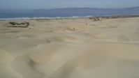 5K stock footage aerial video of panning across sand dunes, revealing ATV riders, Pismo Dunes, California Aerial Stock Footage | DFKSF02_027