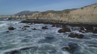 5K stock footage aerial video fly over waves rolling into rock formations, coastal cliffs, Avila Beach, California Aerial Stock Footage | DFKSF02_061