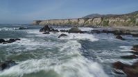 5K stock footage aerial video of flying over waves rolling into rock formations, coastal cliffs, Avila Beach, California Aerial Stock Footage | DFKSF02_062