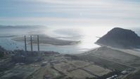 5K stock footage aerial video of flying by Dynegy Power Plant and smoke stacks, Morro Rock, and the coast, Morro Bay, California Aerial Stock Footage | DFKSF03_011