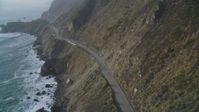 5K stock footage aerial video of following Highway 1 coastal road past cliffs, tracking a white car, Big Sur, California Aerial Stock Footage | DFKSF03_112