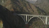 5K stock footage aerial video of flying over ocean kelp to reveal small bridge on Highway 1 and cliffs, Big Sur, California Aerial Stock Footage | DFKSF03_115