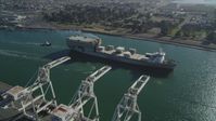 5K stock footage aerial video of a reverse view of a cargo ship passing cargo cranes in the Port of Oakland, California Aerial Stock Footage | DFKSF09_020